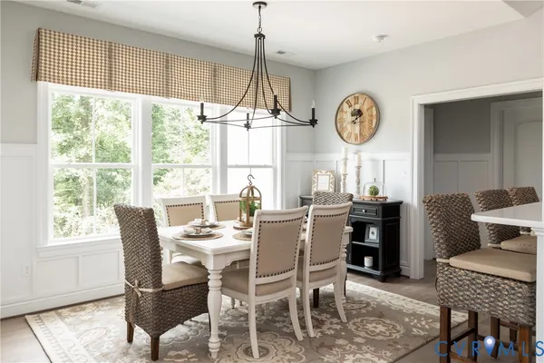 a dining room with furniture a large window and a clock