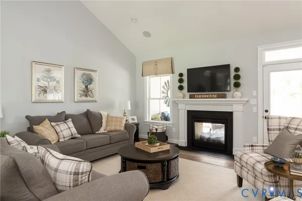 a living room with furniture a fireplace and a flat screen tv