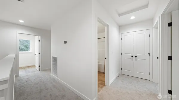 a view of a hallway with closet and bathroom