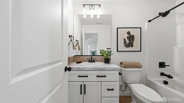 a bathroom with a sink a toilet a mirror and shower curtain