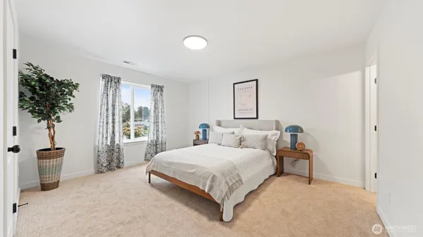a bedroom with a bed and a potted plant
