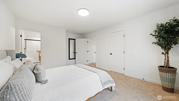 a bedroom with a bed and a potted plant