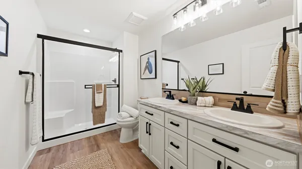 a bathroom with a double vanity sink mirror and shower