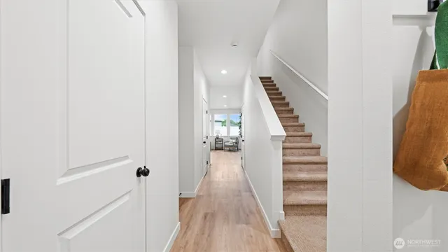 a view of a hallway with wooden floor and entryway