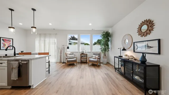 a large white kitchen with stainless steel appliances granite countertop a stove a sink dishwasher and a wooden cabinets with wooden floor