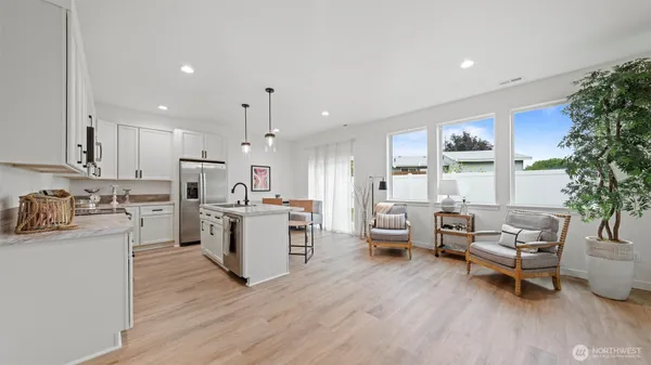 a kitchen with stainless steel appliances kitchen island wooden floors and white cabinets