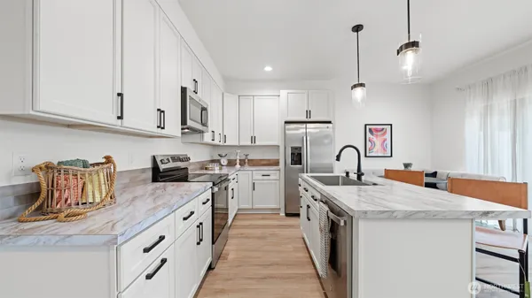 a kitchen with stainless steel appliances granite countertop a sink stove and refrigerator