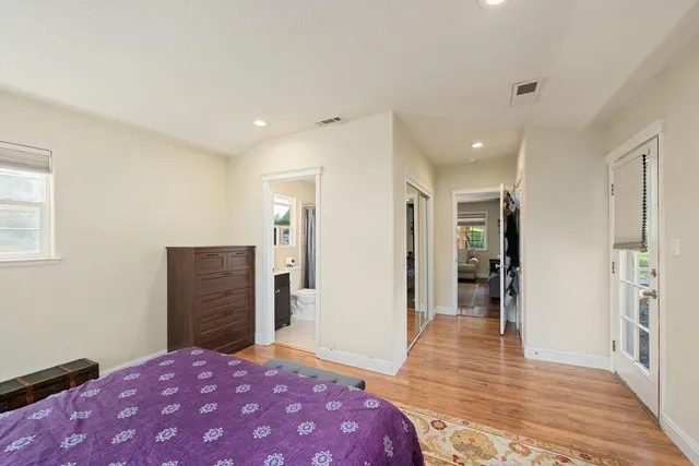 a bedroom with a bed and wooden floor