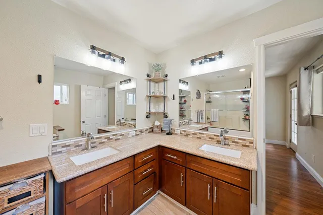 a bathroom with a granite countertop sink a large mirror and a toilet