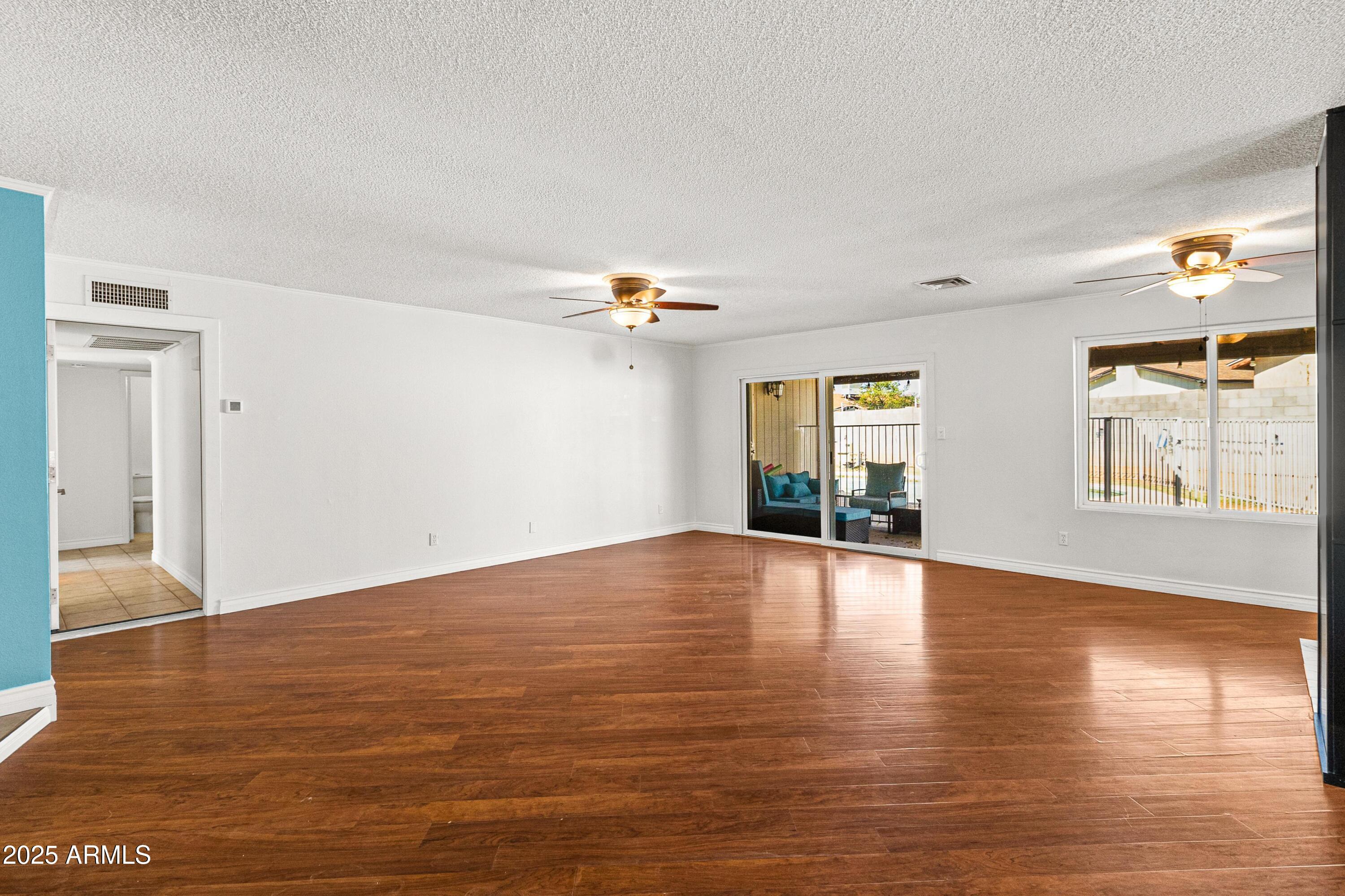 2846 West Villa Rita Drive Phoenix, AZ 85053 - Photo 3 of 24 a view of empty room with wooden floor and fan