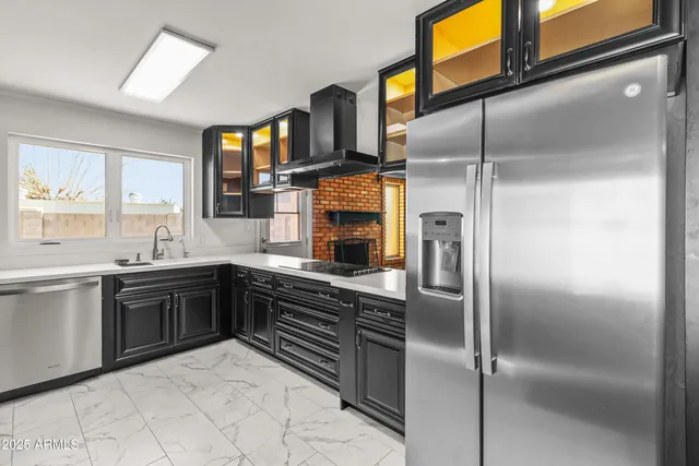 a kitchen with stainless steel appliances granite countertop a refrigerator and a stove top oven