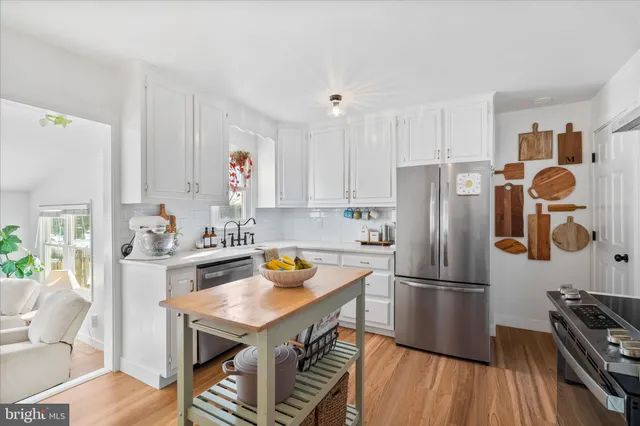 a kitchen with stainless steel appliances a stove a refrigerator and a fireplace