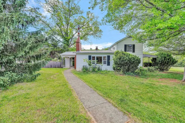 a front view of a house with yard and green space