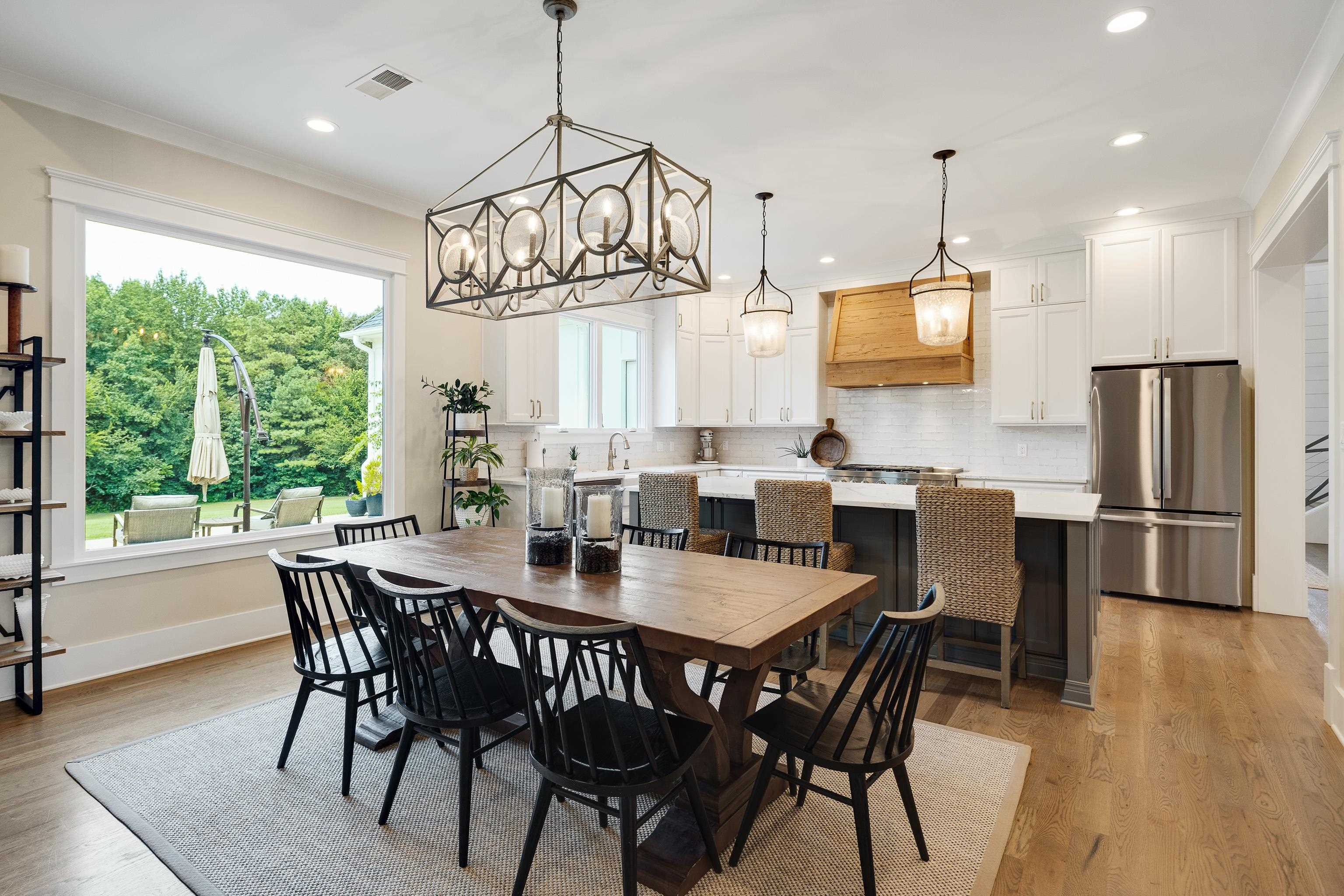 805 Shady Grove Road Williston, TN 38076 - Photo 11 of 40 Hardwood flooring throughout, large window overlooking the outdoor area, white shaker-style cabinetry, stainless steel refrigerator, and recessed lighting