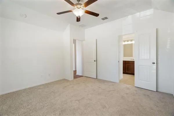 an empty room with closet and a chandelier fan