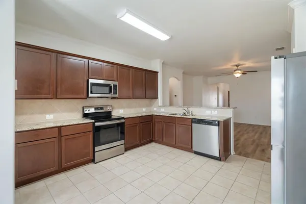 a large kitchen with cabinets appliances and a sink
