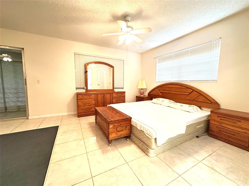 57 Markham C, Unit 57 Deerfield Beach, FL 33442 - Photo 11 of 76 a bedroom with a bed and a night stand