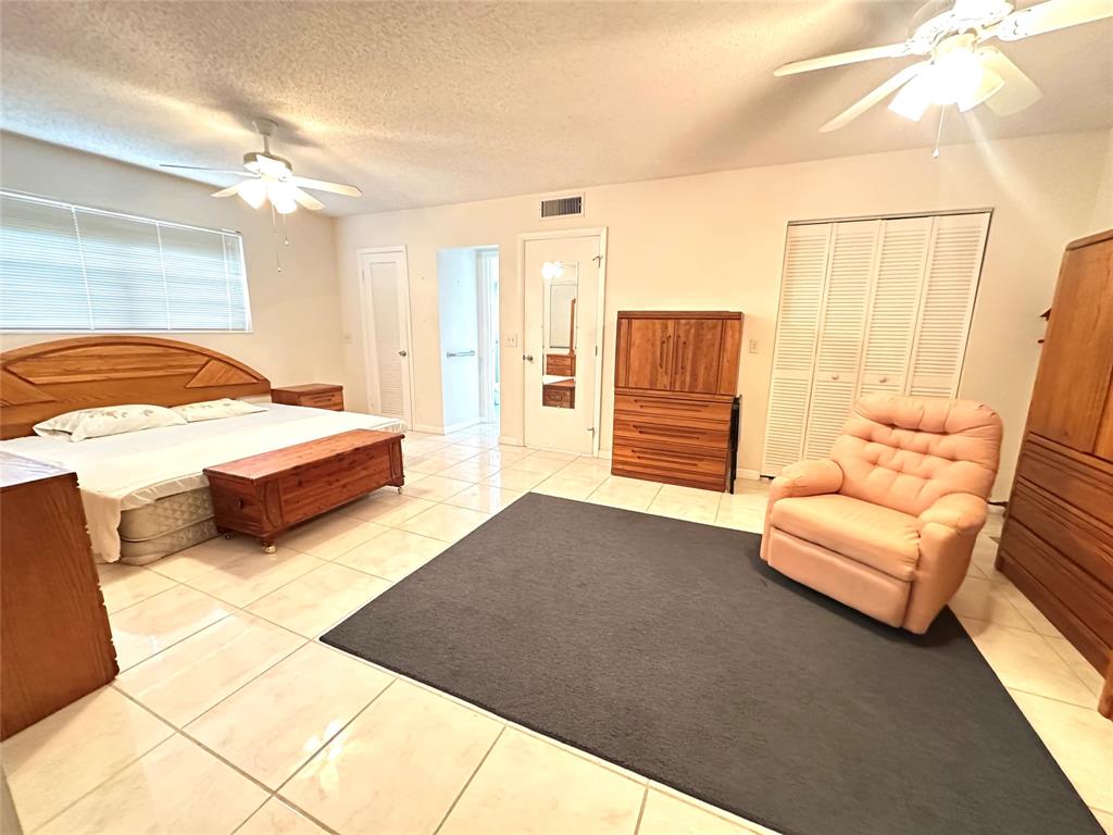 57 Markham C, Unit 57 Deerfield Beach, FL 33442 - Photo 18 of 76 a spacious bedroom with a bed and a couch