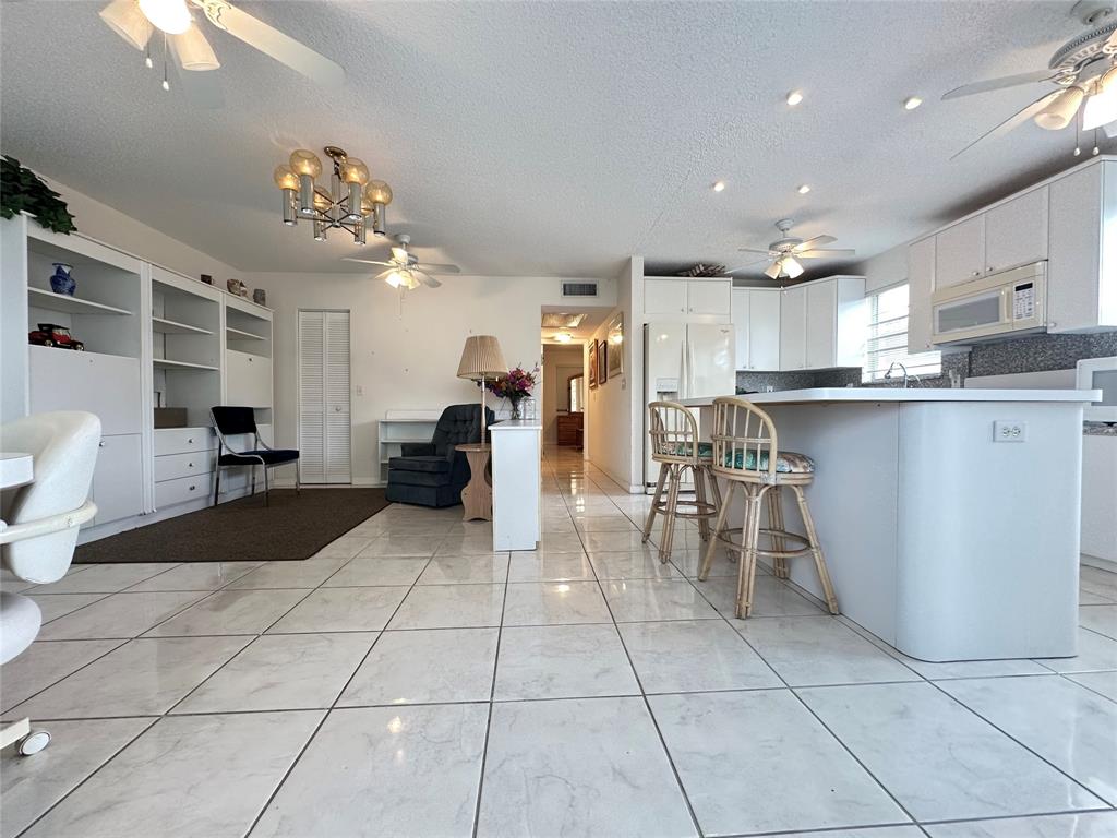 57 Markham C, Unit 57 Deerfield Beach, FL 33442 - Photo 2 of 76 a large kitchen with stainless steel appliances lots of counter space and chair