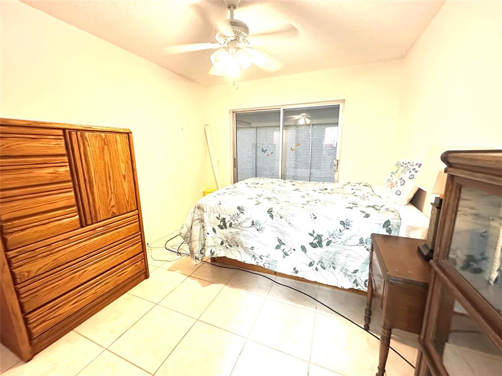 57 Markham C, Unit 57 Deerfield Beach, FL 33442 - Photo 29 of 76 a bedroom with a bed and a flat screen tv