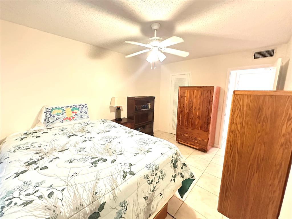 57 Markham C, Unit 57 Deerfield Beach, FL 33442 - Photo 30 of 76 a bedroom with a bed and a chandelier