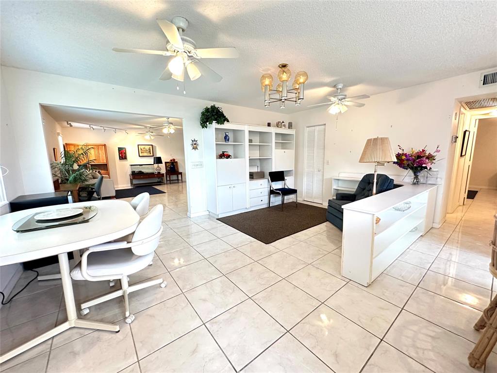 57 Markham C, Unit 57 Deerfield Beach, FL 33442 - Photo 3 of 76 a living room with kitchen island granite countertop furniture and a view of kitchen