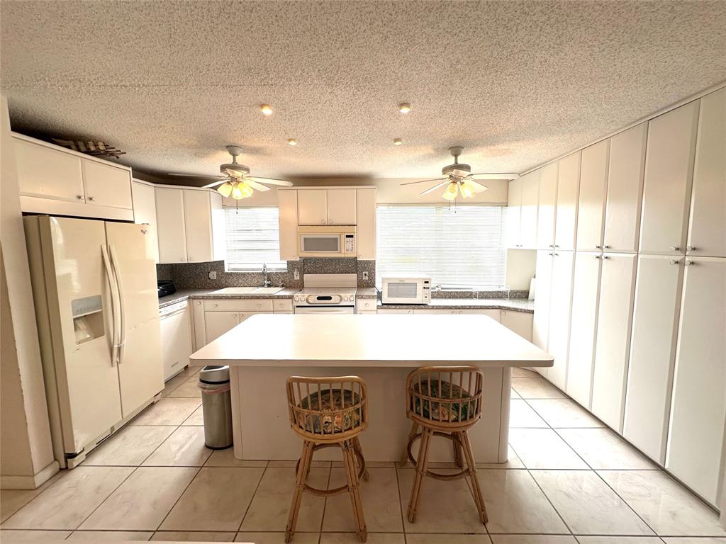 57 Markham C, Unit 57 Deerfield Beach, FL 33442 - Photo 6 of 76 a kitchen with stainless steel appliances granite countertop a refrigerator a sink and a stove
