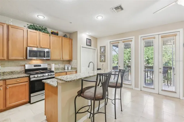 a kitchen with stainless steel appliances granite countertop a sink stove and refrigerator