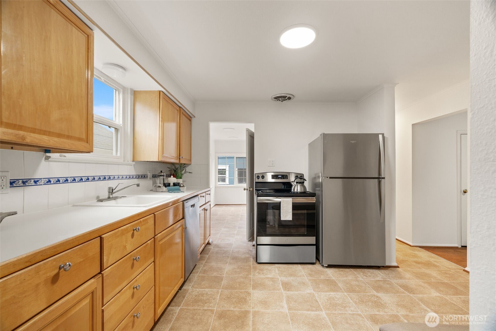921 North 50th Street Seattle, WA 98103 - Photo 15 of 32 a kitchen with stainless steel appliances a refrigerator sink and cabinets