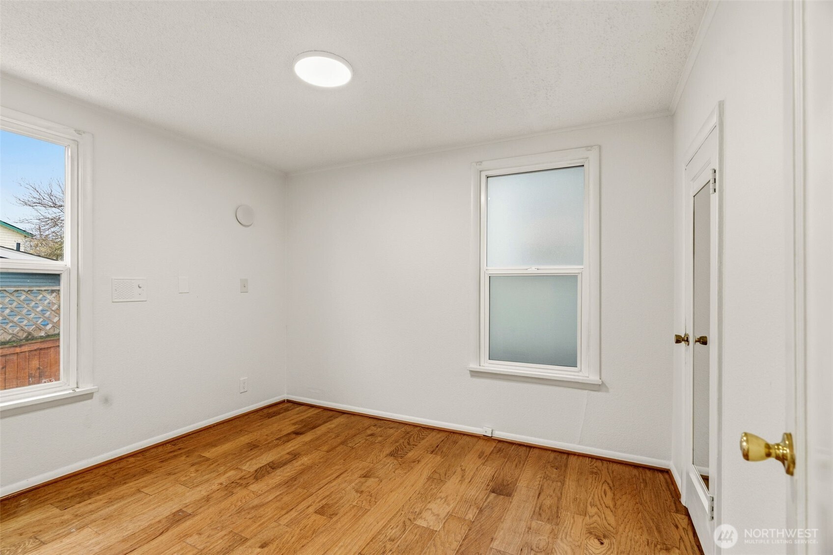 921 North 50th Street Seattle, WA 98103 - Photo 18 of 32 a view of an empty room with wooden floor and a window