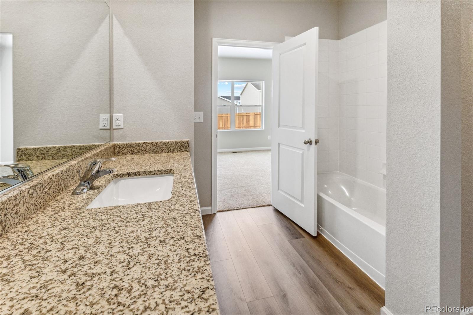 2144 Alyssa Street Fort Lupton, CO 80621 - Photo 11 of 38 a bathroom with a granite countertop sink a vanity and shower