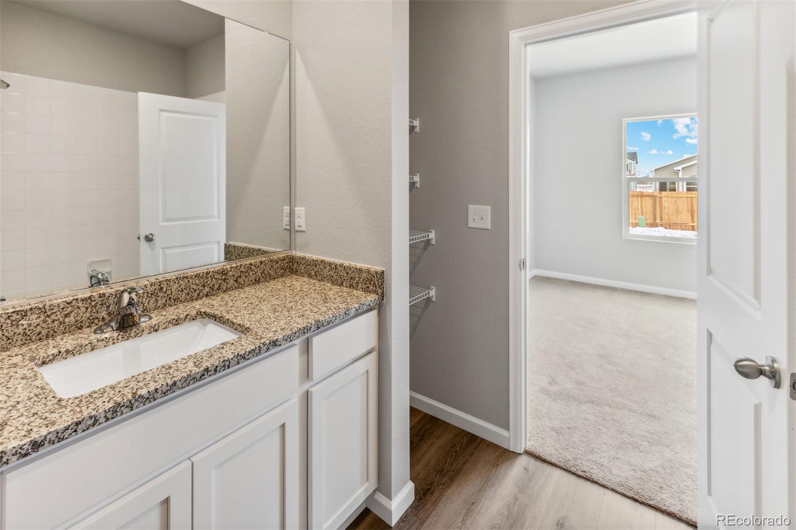 2144 Alyssa Street Fort Lupton, CO 80621 - Photo 12 of 38 a bathroom with a granite countertop sink and a mirror