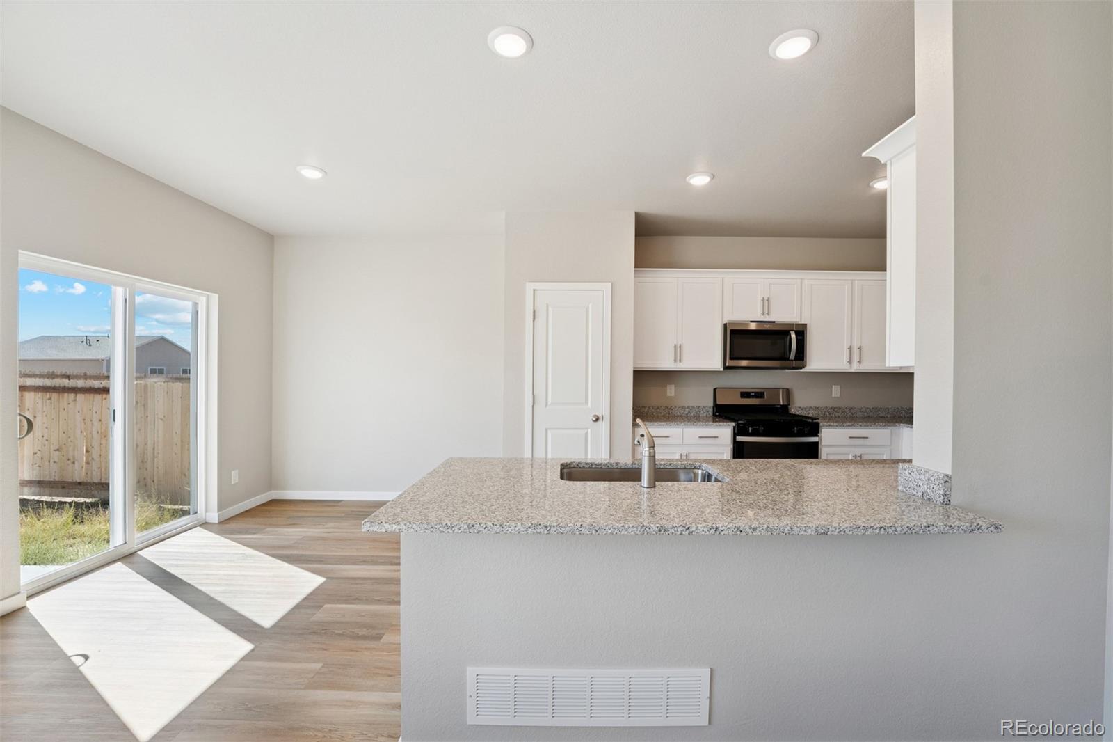 2144 Alyssa Street Fort Lupton, CO 80621 - Photo 5 of 38 a view of kitchen with stainless steel appliances kitchen island sink and refrigerator