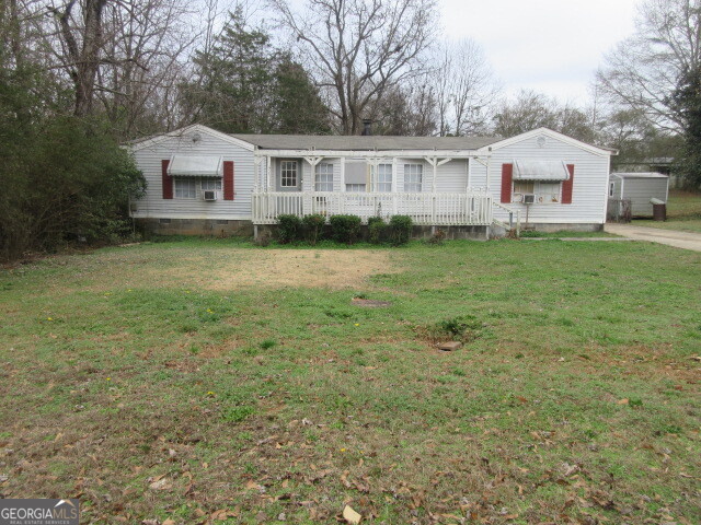 71 Highpoint Lane Locust Grove, GA 30248 - Photo 2 of 3 a front view of a house with a garden and trees