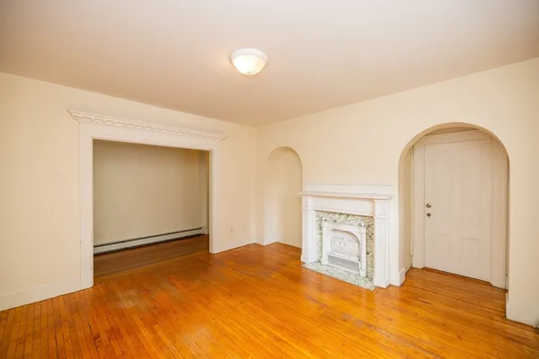 a view of empty room with wooden floor