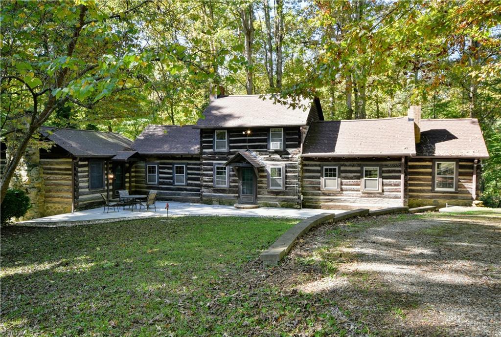Incredible enterance to this late 1800's era (with later additions) hand-hewn home! Circular gravel driveway frames up this blissful cabin in the forest.