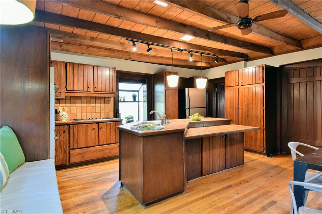 6068 Hedgerow Circle Clemmons, NC 27012 - Photo 6 of 35 Kitchen with cooktop, center island, and gorgeous beamed wood ceiling. Seller has a plan for potential kitchen renovation that can be viewed on-site.