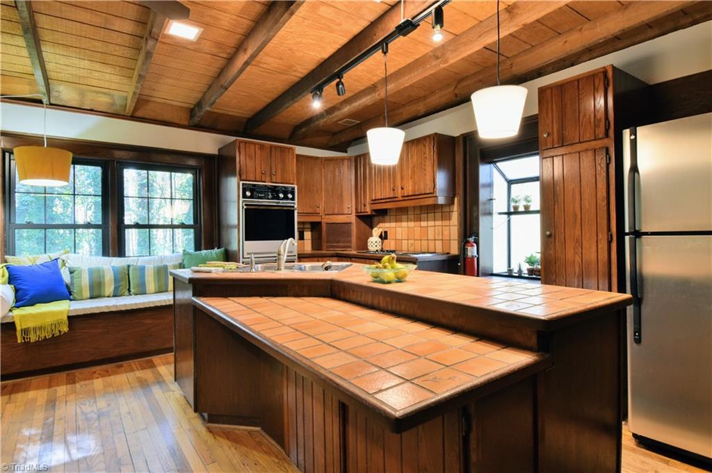 6068 Hedgerow Circle Clemmons, NC 27012 - Photo 7 of 35 Center island with dine-at bar, charming window seat and wall ovens. Such a private view through the replacement windows!