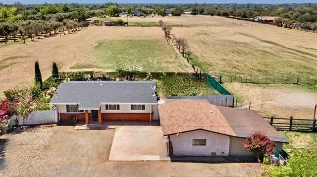 an aerial view of a house with a yard and lake view