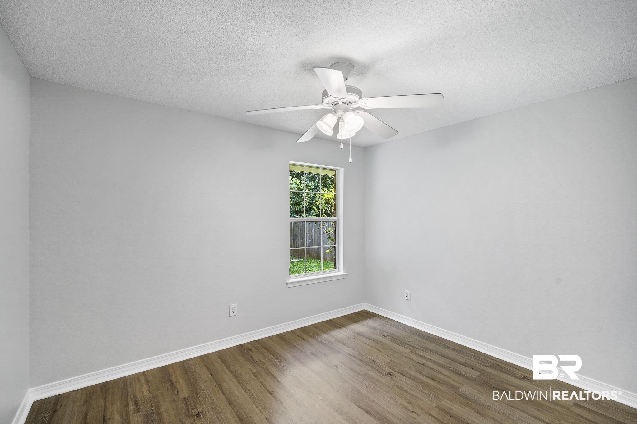 9814 Woolrich Avenue Fairhope, AL 36532 - Photo 17 of 29 Spare room with ceiling fan, a textured ceiling, and hardwood / wood-style flooring
