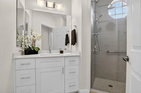 a bathroom with a shower sink and mirror