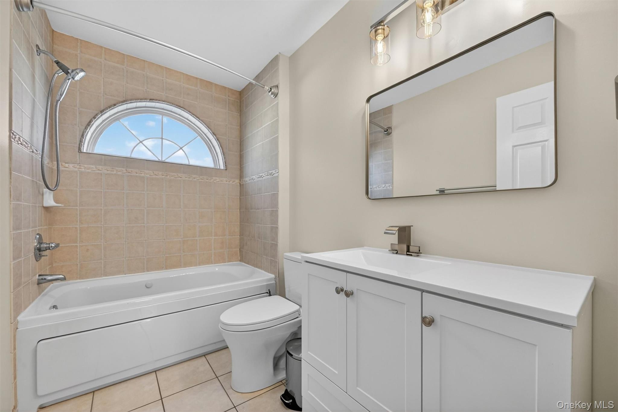 954 Ridgebury Road New Hampton, NY 10958 - Photo 35 of 45 This bathroom is fresh, clean and comfortable, with a bright vanity, tiled tub area, and a charming arched window that brings in natural light. Located on the second floor, this bath serves both the 3rd bedroom and the home office.