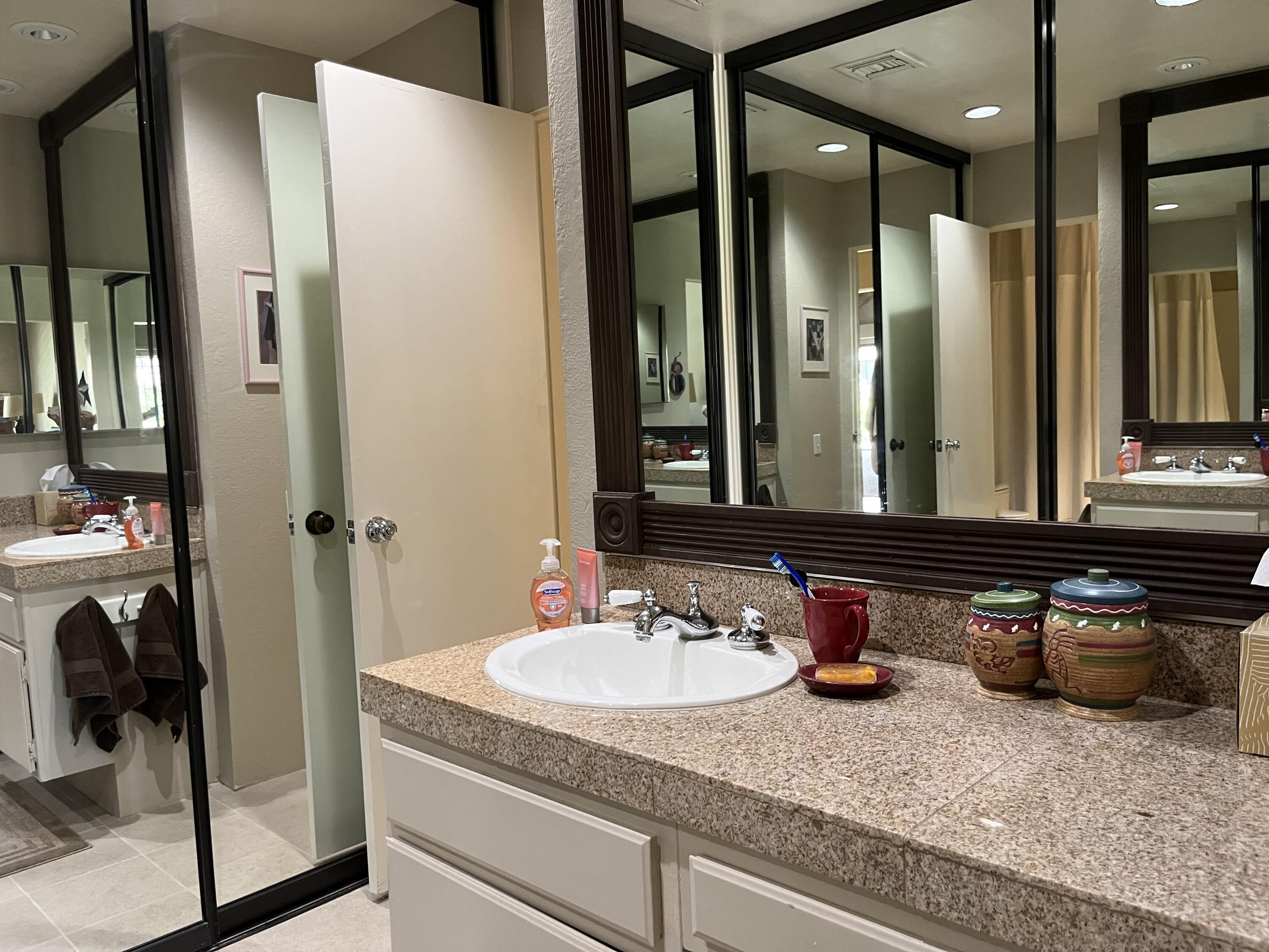 127 South Racquet Club Drive Rancho Mirage, CA 92270 - Photo 15 of 25 a bathroom with a granite countertop sink and a mirror