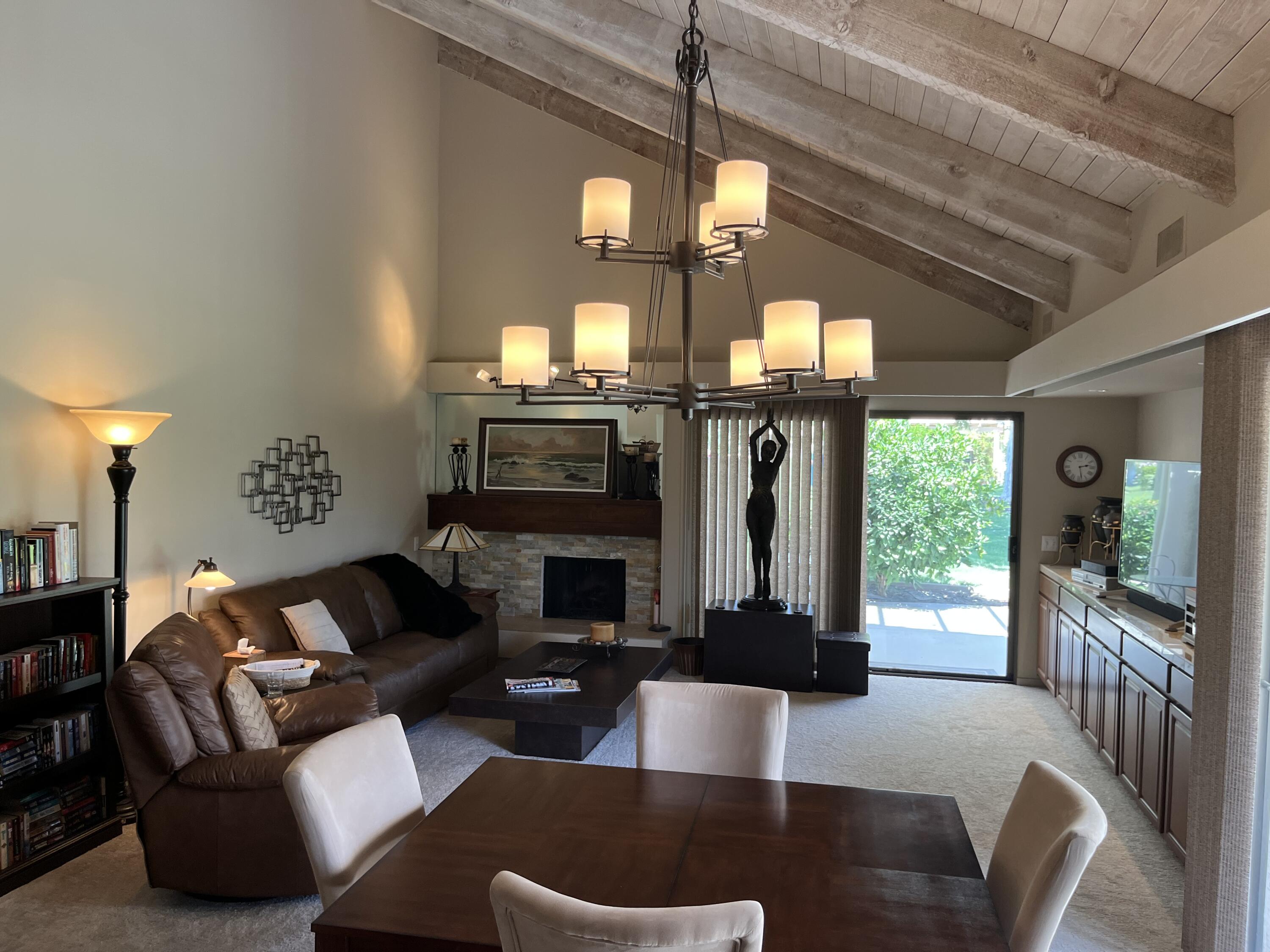 127 South Racquet Club Drive Rancho Mirage, CA 92270 - Photo 17 of 25 a living room with furniture a fireplace and a chandelier
