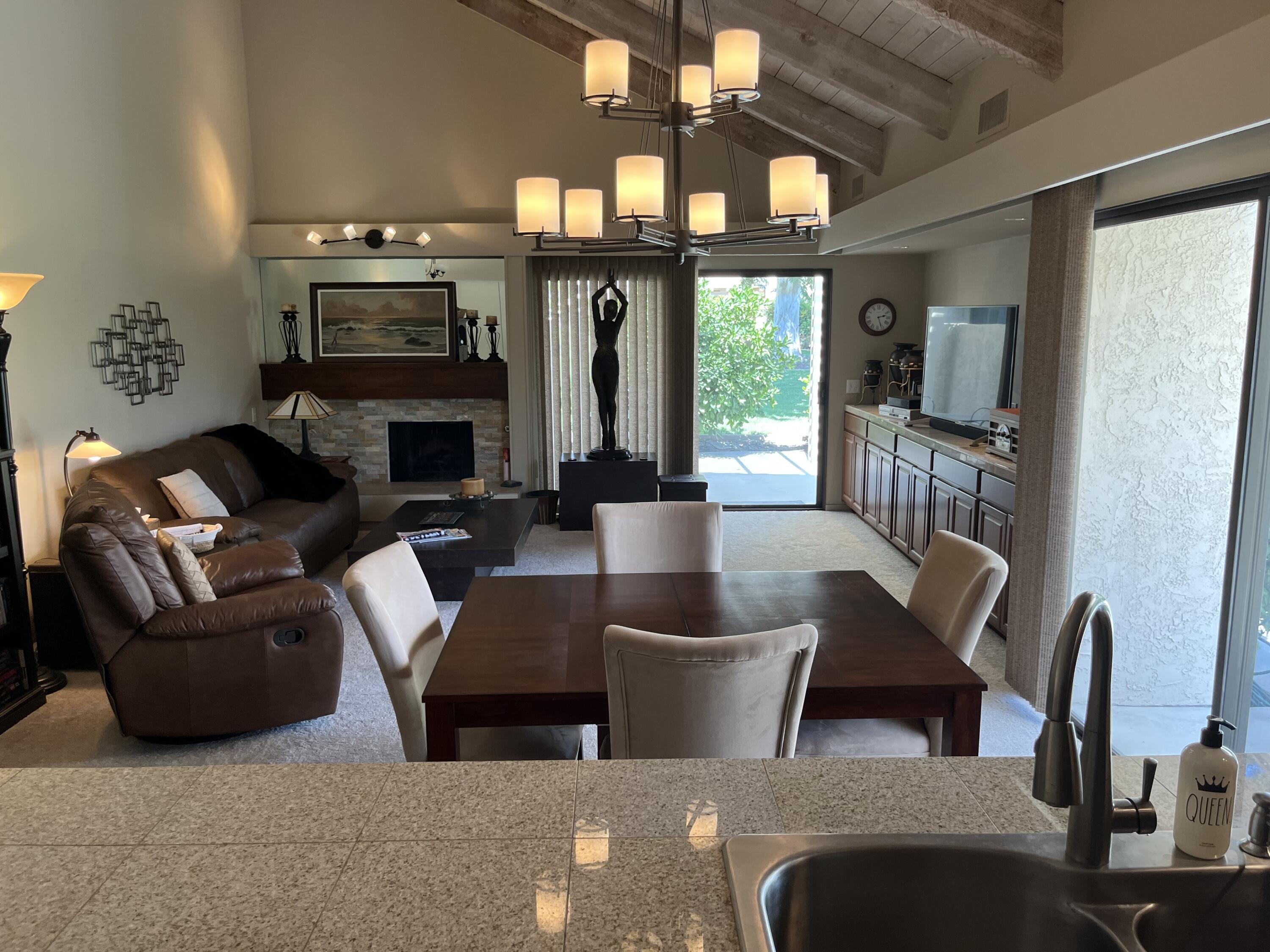 127 South Racquet Club Drive Rancho Mirage, CA 92270 - Photo 18 of 25 a living room with furniture a large window and a fireplace