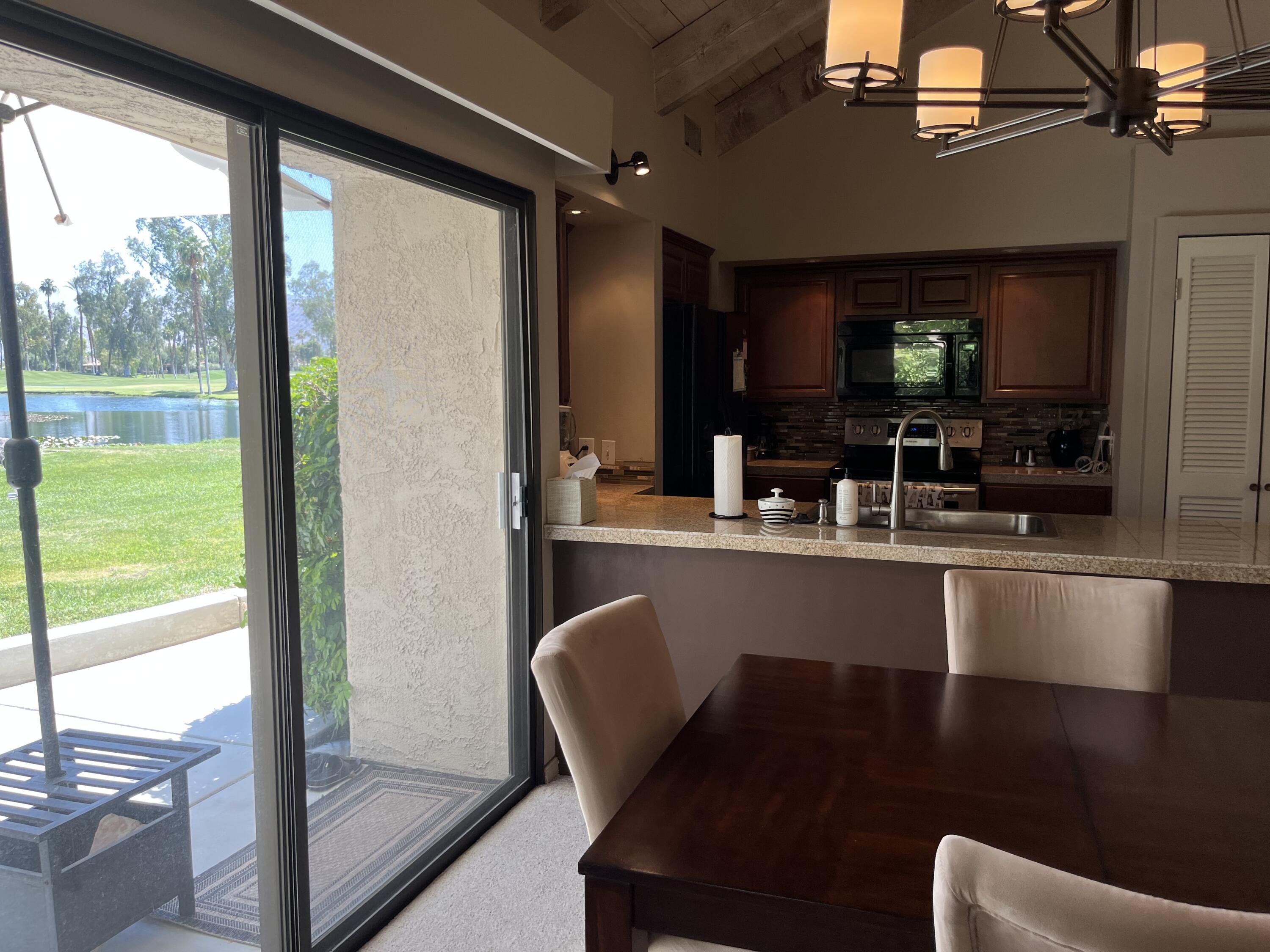 127 South Racquet Club Drive Rancho Mirage, CA 92270 - Photo 19 of 25 a kitchen with a table chairs and entryway