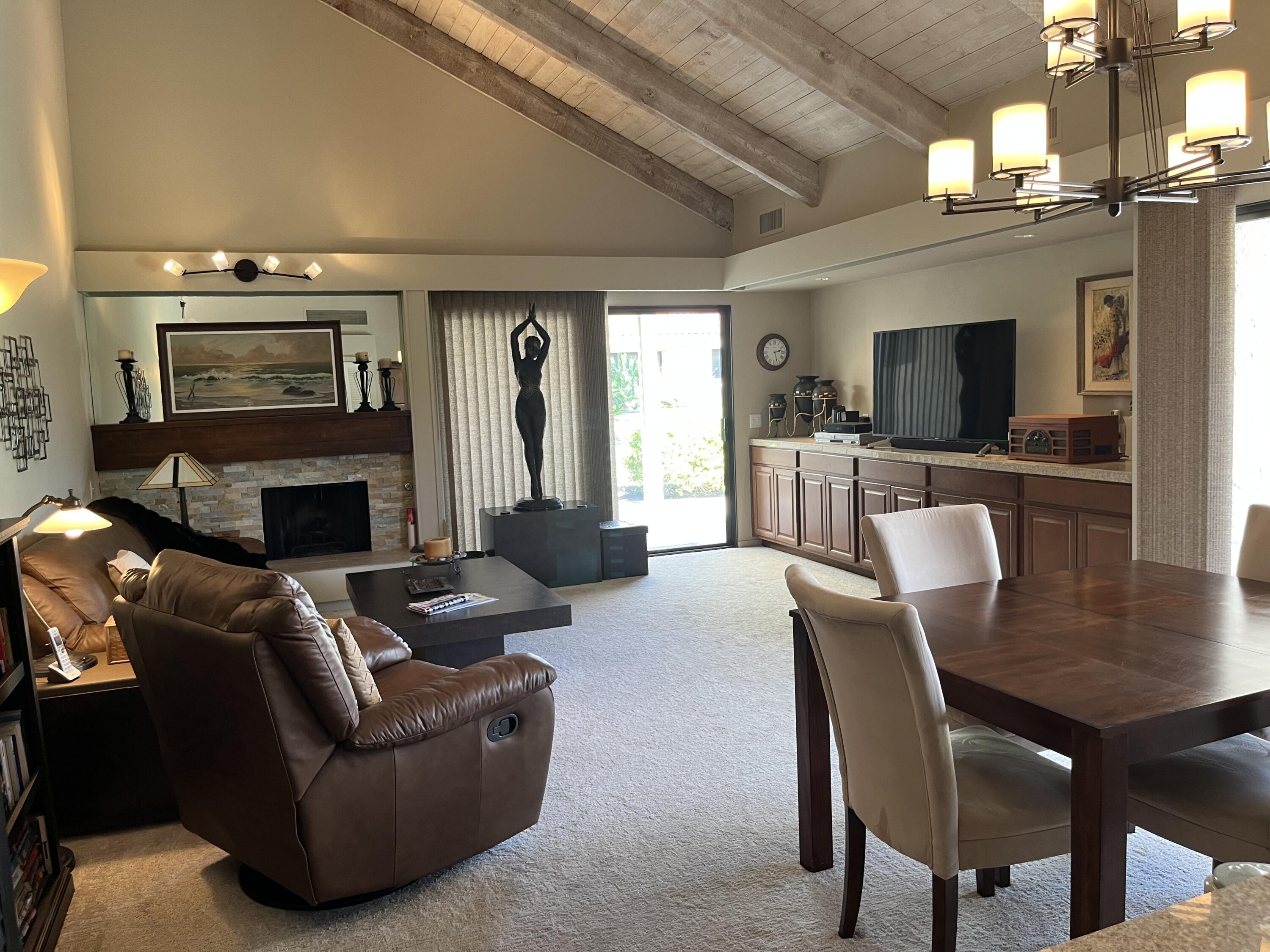 127 South Racquet Club Drive Rancho Mirage, CA 92270 - Photo 2 of 25 a living room with furniture a flat screen tv and a fireplace