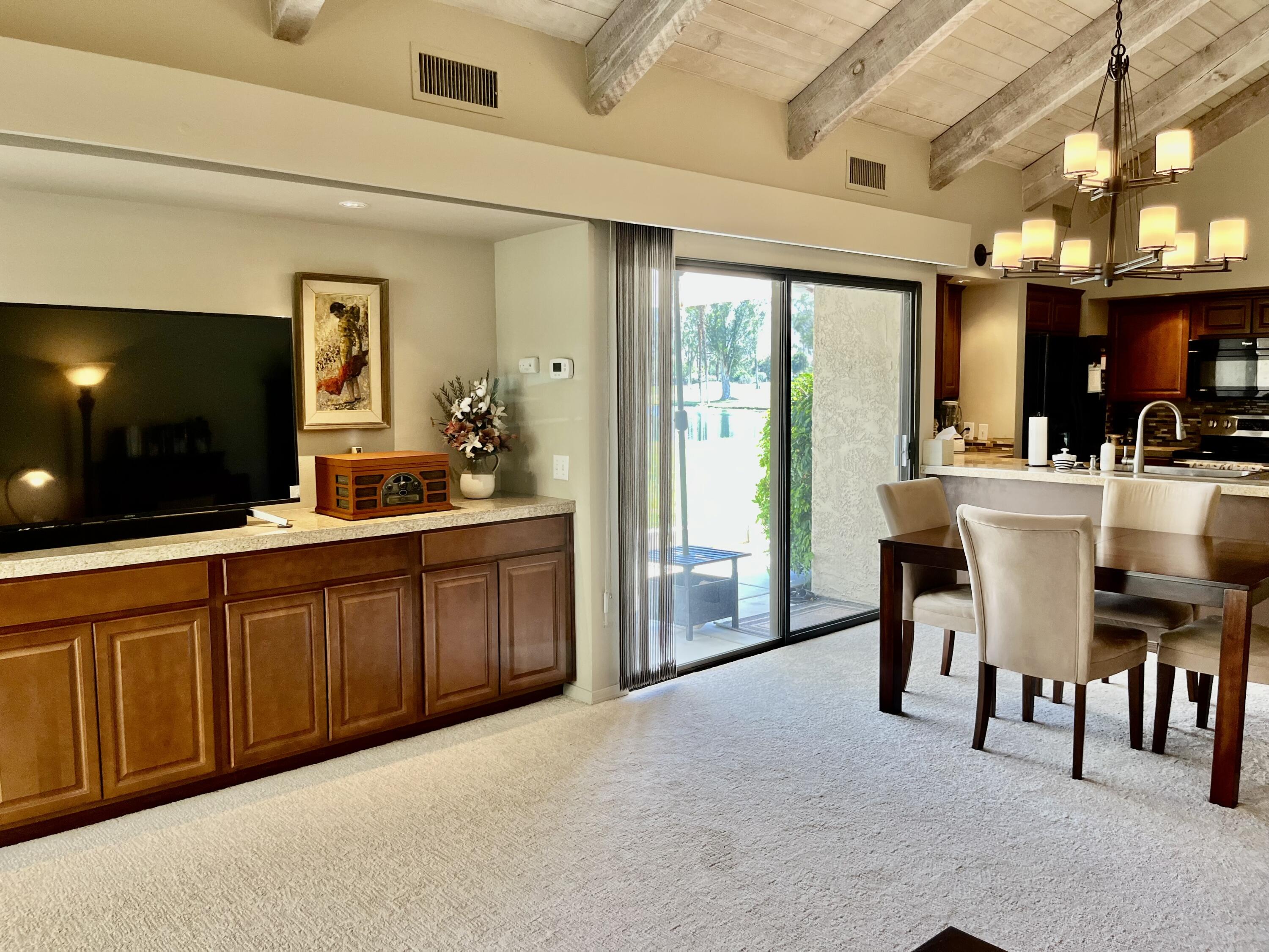 127 South Racquet Club Drive Rancho Mirage, CA 92270 - Photo 6 of 25 a large living room with stainless steel appliances granite countertop furniture a fireplace and a flat screen tv