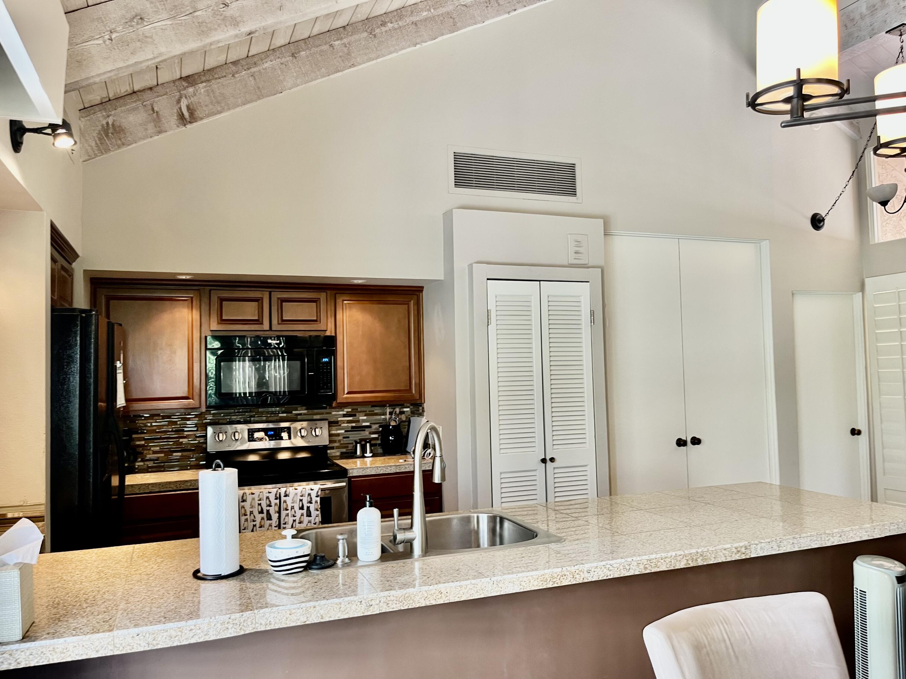 127 South Racquet Club Drive Rancho Mirage, CA 92270 - Photo 7 of 25 a kitchen with a sink stainless steel appliances and cabinets