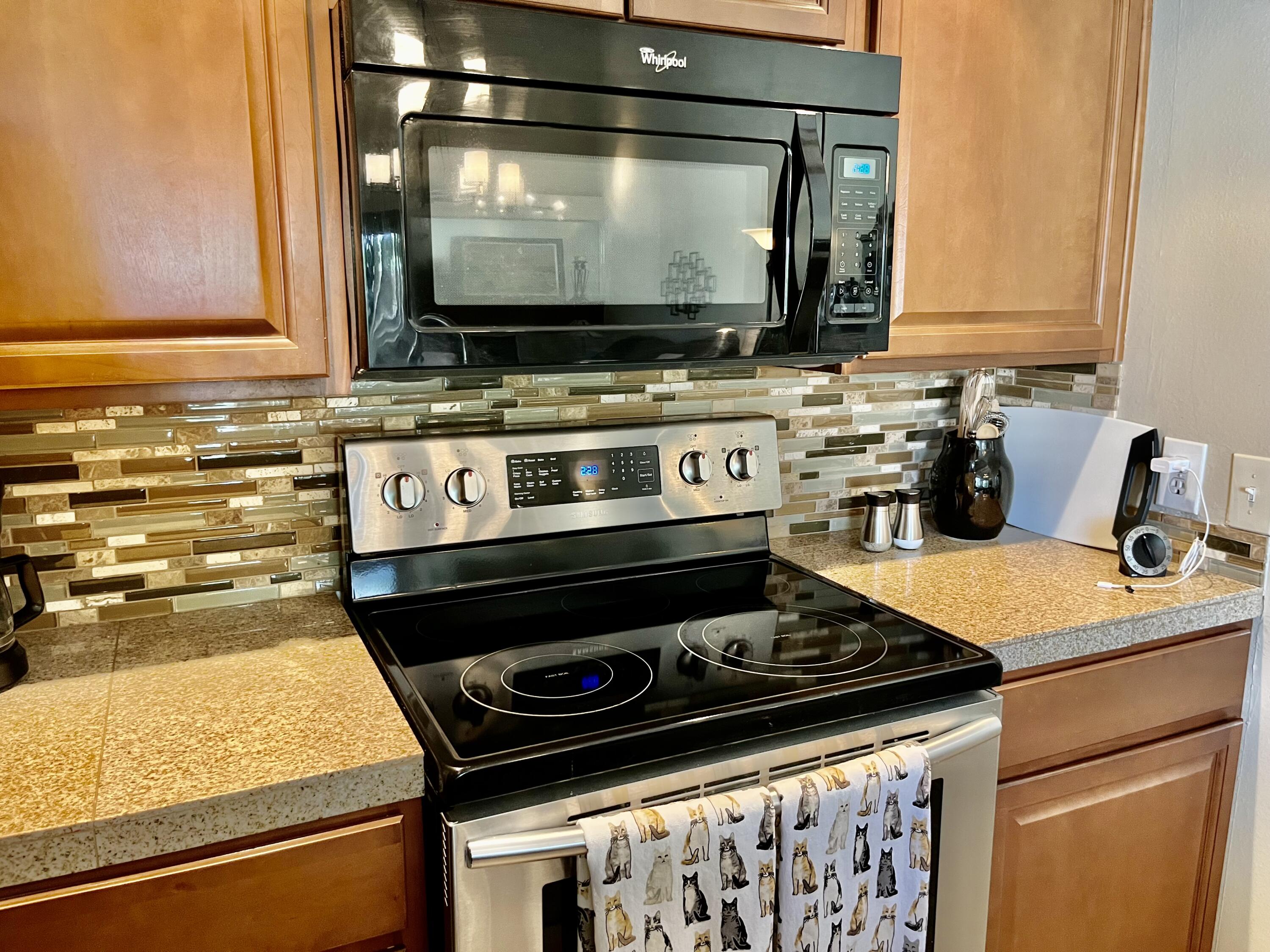 127 South Racquet Club Drive Rancho Mirage, CA 92270 - Photo 8 of 25 a kitchen with stainless steel appliances a stove and a microwave
